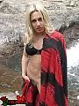 A transsexual cutie posing naked by a  waterfall all