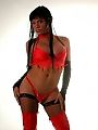 A kinky ladyboy hiding her shapes under red lingerie all
